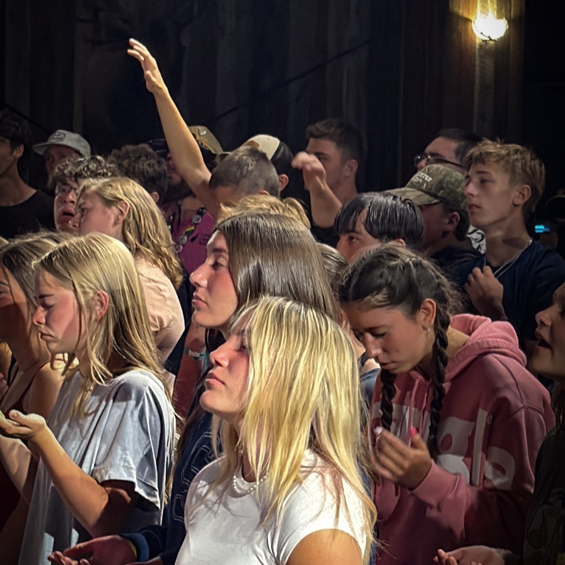 Students singing with hands raised at MVF Students summer camp